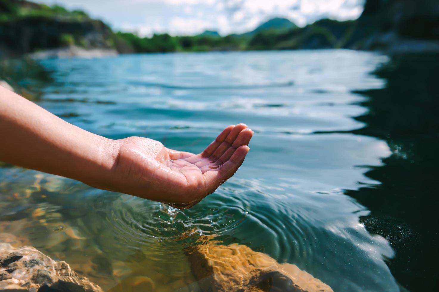 Hand, die Wasser im Teich hält foto