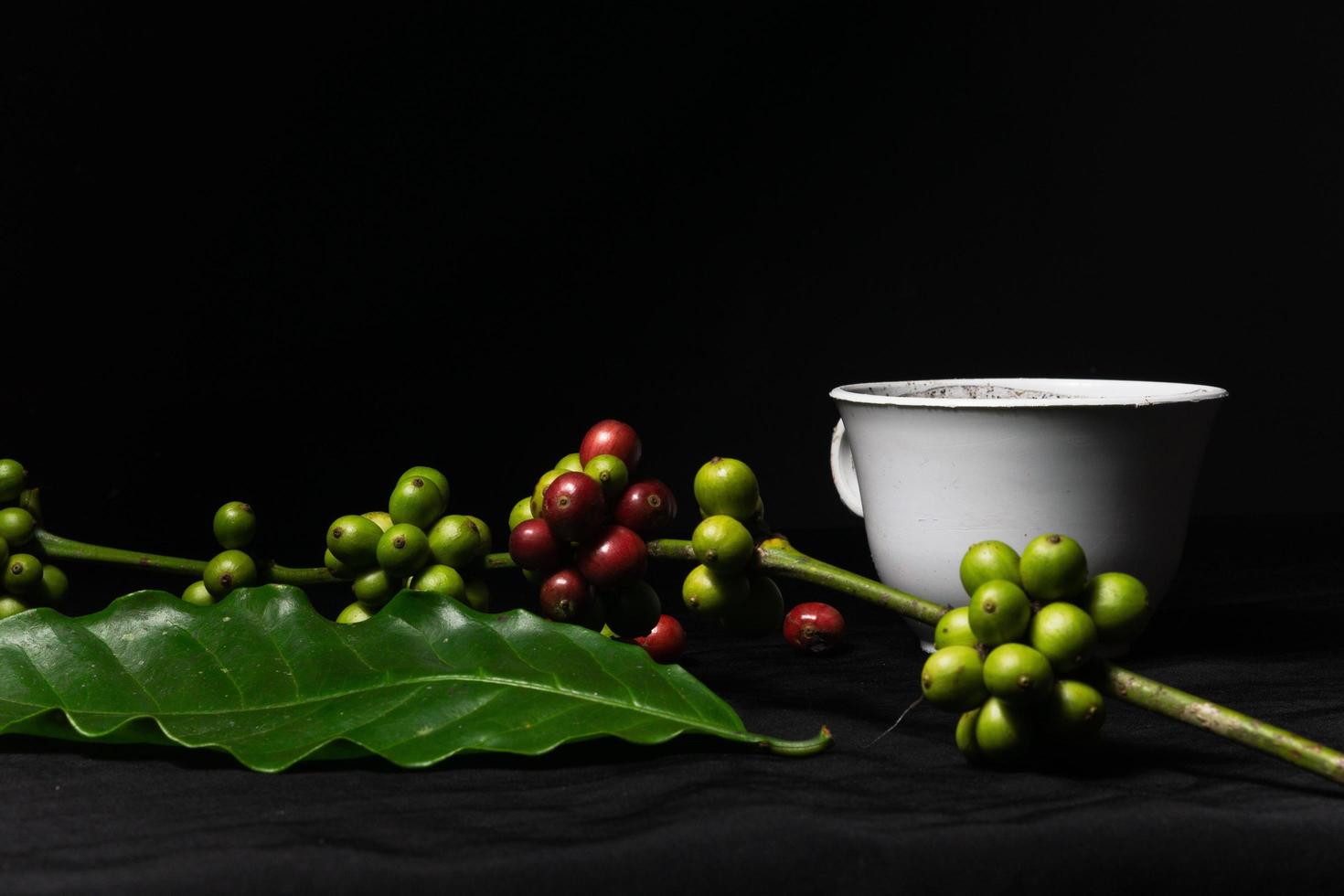 Foto einer Tasse schwarzen Kaffees und frischer originaler Kaffeebohnen auf schwarzem Hintergrund. perfekt für die Gestaltungselemente des Barista, Cafés und der Kaffeeindustrie.