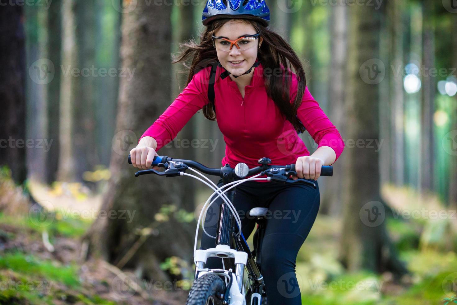 Mädchen Fahrrad fahren auf Waldwegen foto