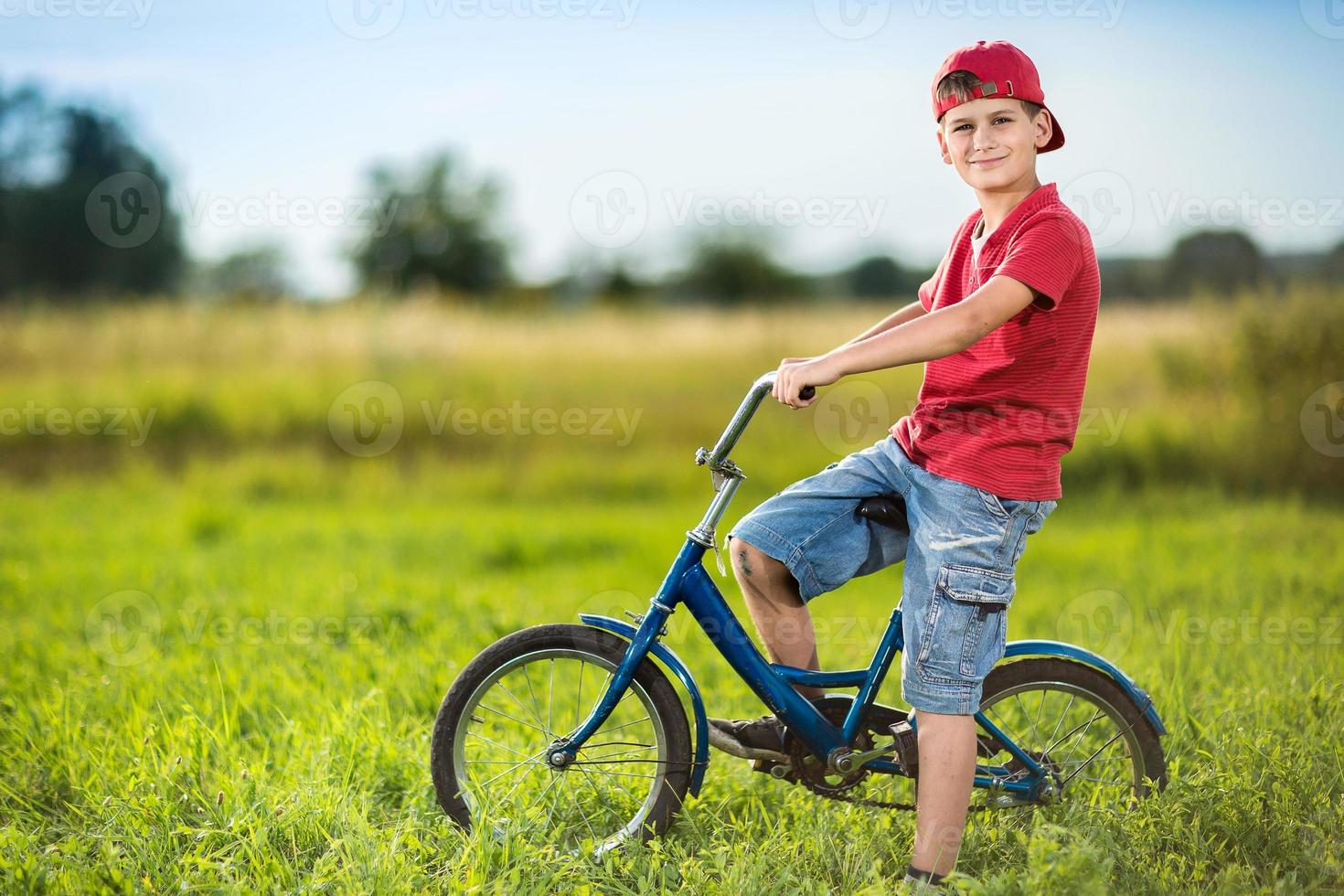 Junge, der Fahrrad in einem Park reitet foto