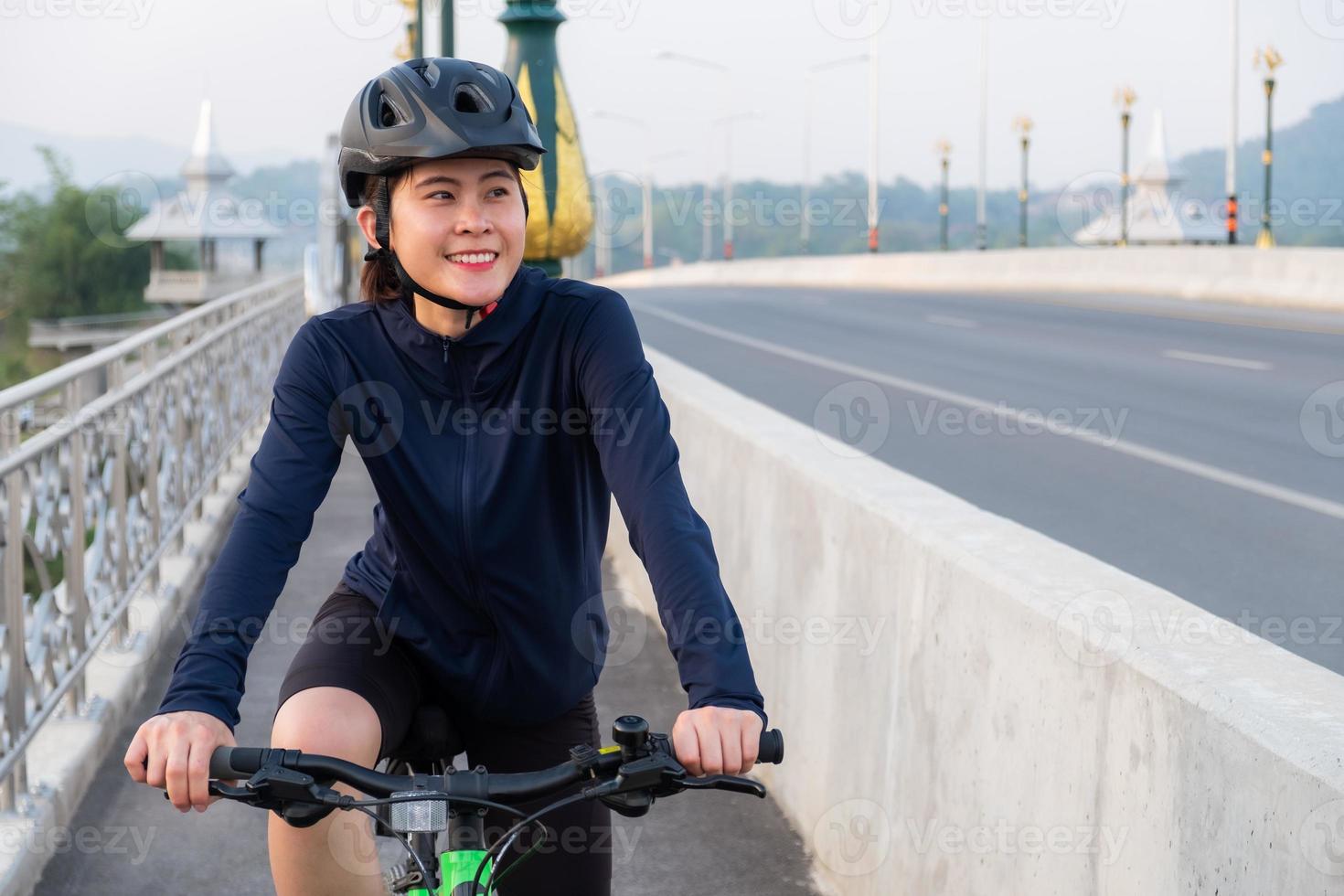 Junge asiatische Radfahrerin trainiert mit dem Fahrrad. Radfahren ist großartig für diejenigen, die nach einer anderen Form von Cardio- oder Aerobic-Übungen als Laufen suchen. foto