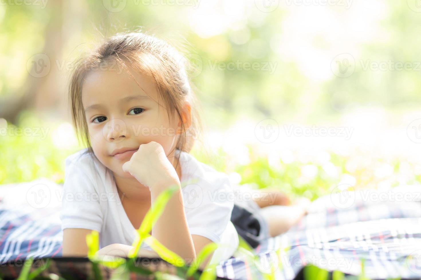 porträtgesicht des niedlichen asiatischen kleinen mädchens und des kindes glück und spaß im park im sommer, lächeln und glücklich vom asiatischen kind und entspannen im garten, lebensstil-kindheitskonzept. foto