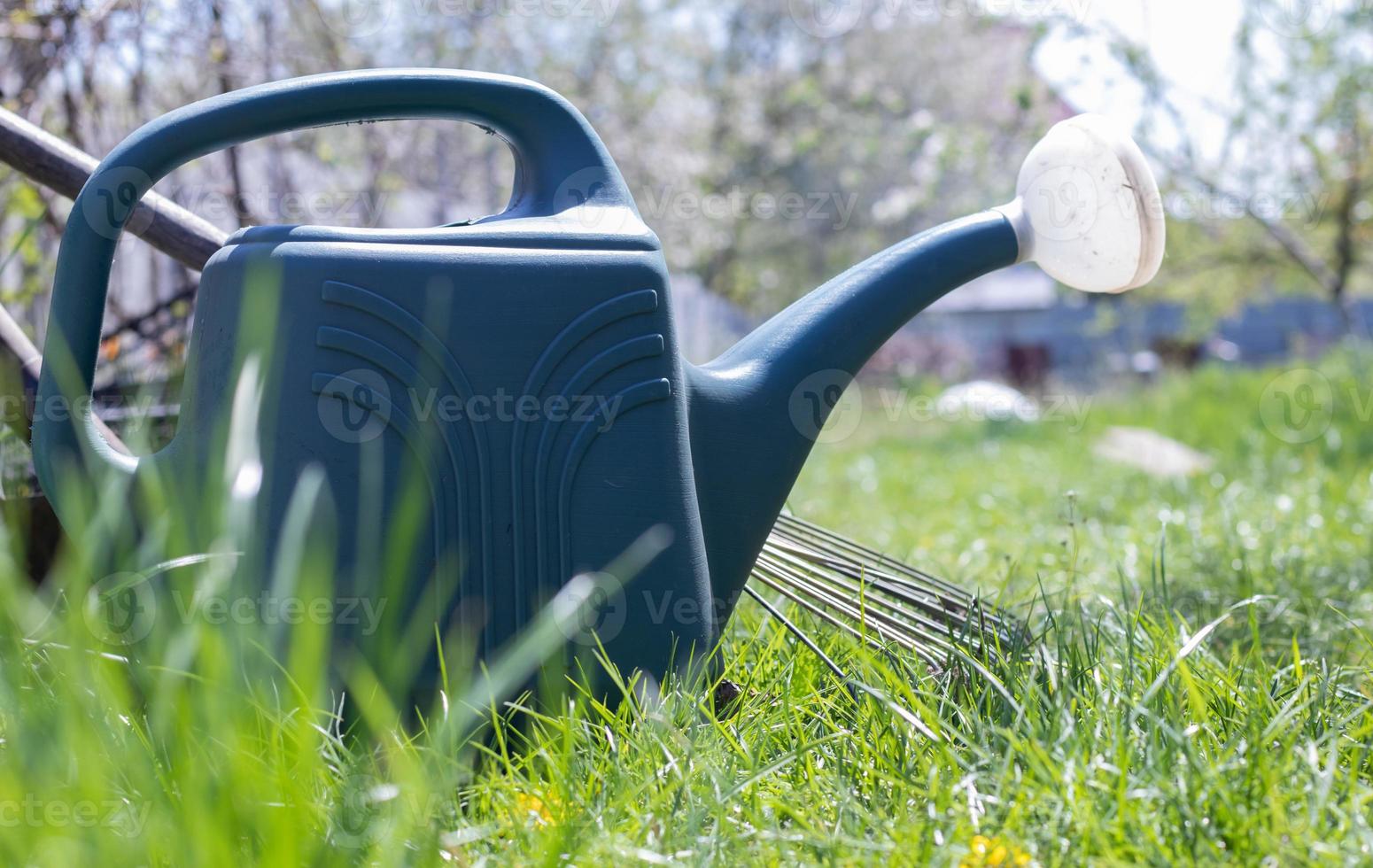 Blauer Plastiktopf zum Gießen im Garten. wässern kann. Gießkanne für Blumen auf der Straße, im Garten oder Garten an einem warmen sonnigen Sommertag. foto