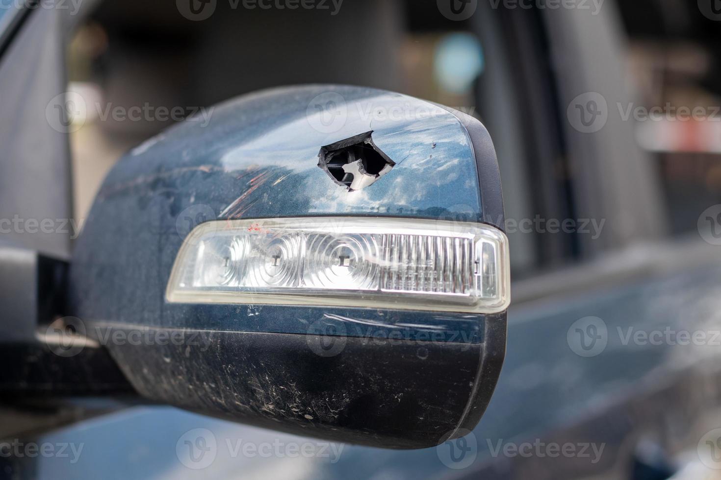 Schließen Sie den kaputten linken Rückspiegel eines Autos in Blau. Autoversicherungskonzept. zerbrochenes Seitenglas des Autos auf der Fahrerseite infolge eines Unfalls. krimineller Vorfall. foto