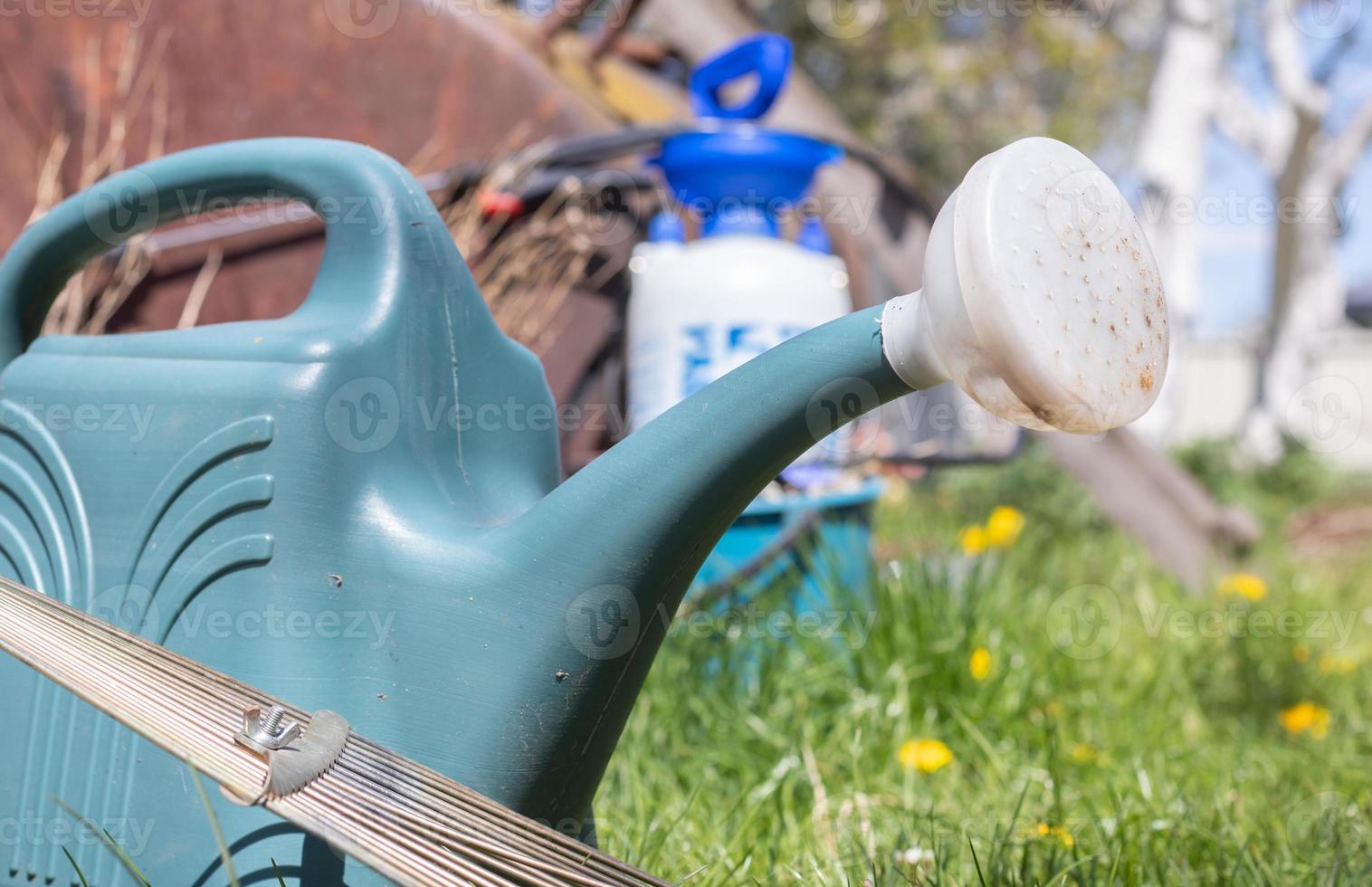 Blauer Plastiktopf zum Gießen im Garten. wässern kann. Gießkanne für Blumen auf der Straße, im Garten oder Garten an einem warmen sonnigen Sommertag. foto