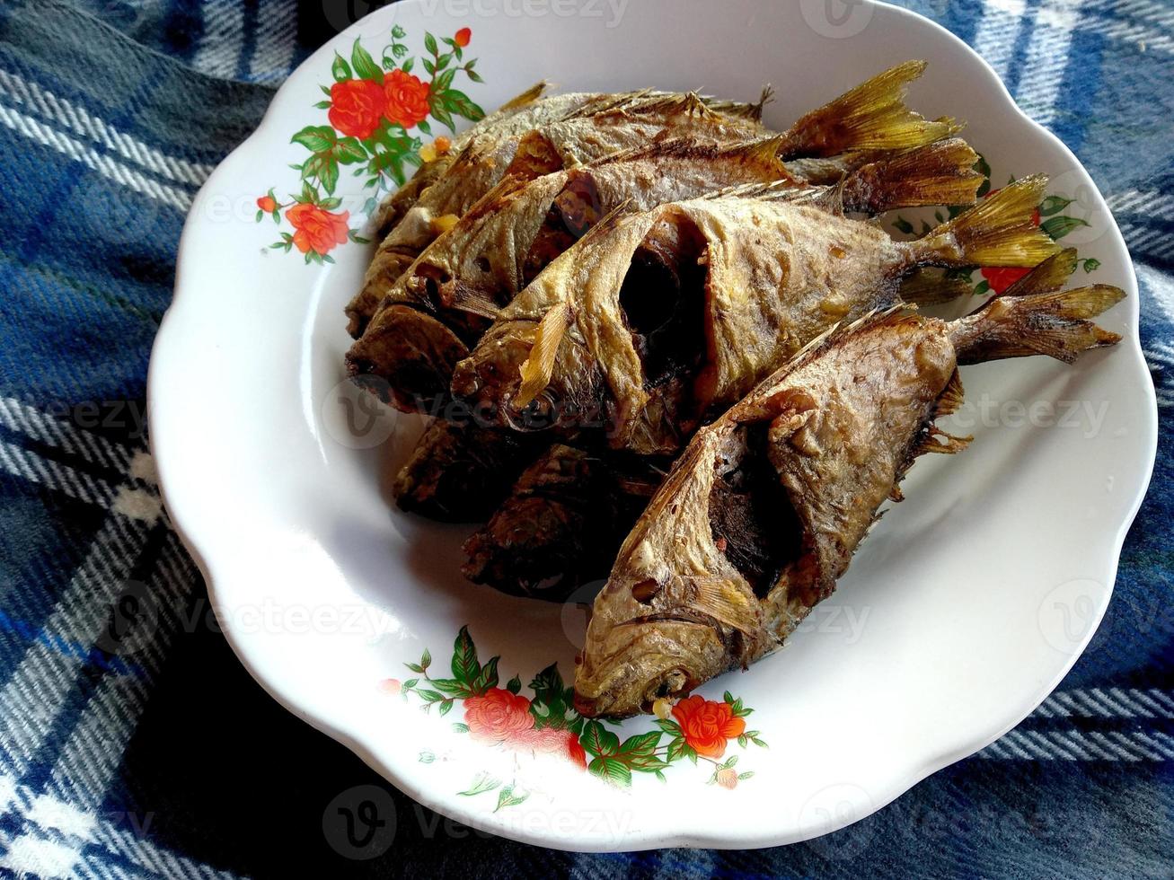 Ikan Goreng oder gebratener Fisch auf einem Teller. traditionelles indonesisches kulinarisches essen foto