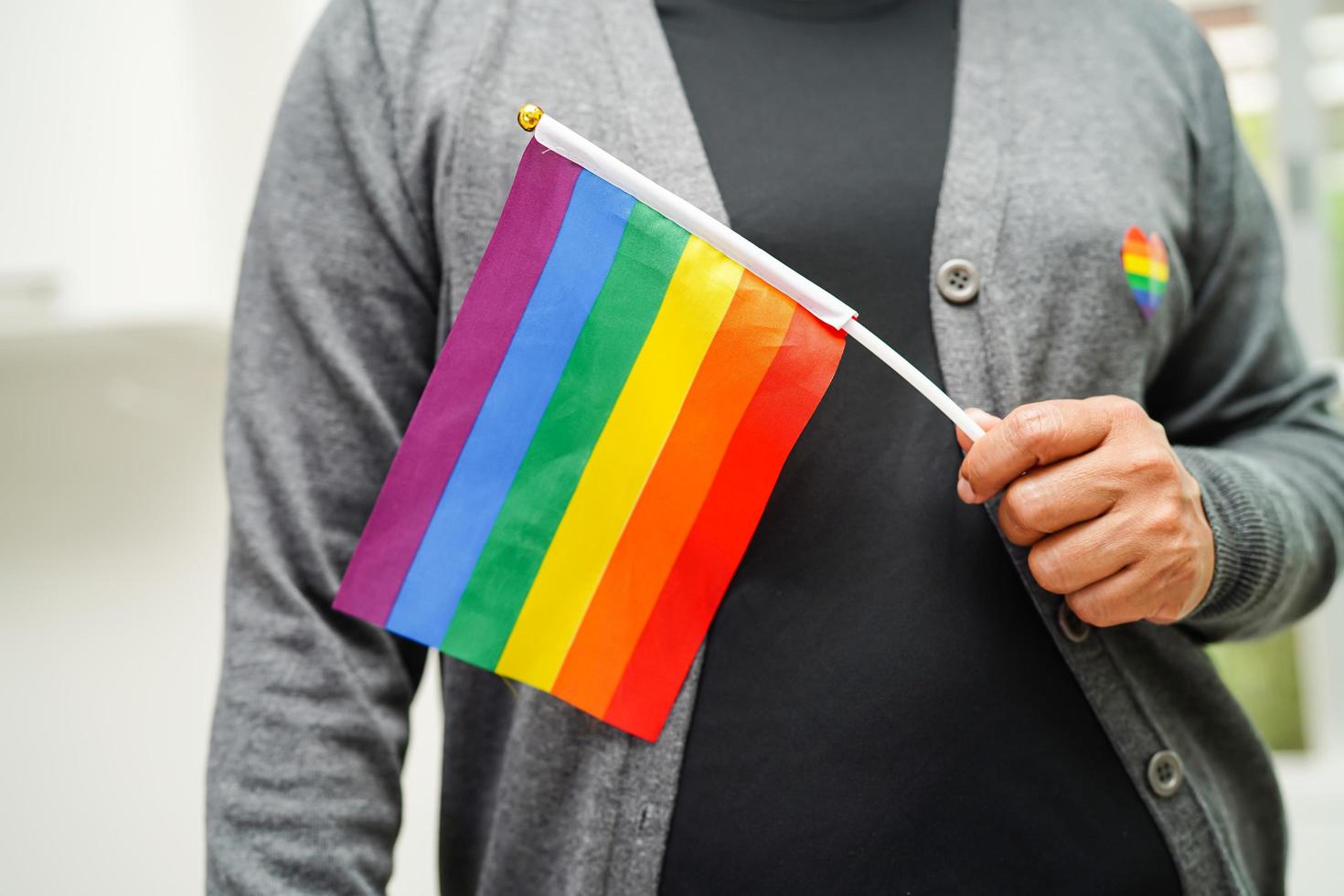 asiatische frau mit regenbogenflagge, lgbt-symbolrechten und geschlechtergleichstellung, lgbt-stolzmonat im juni. foto