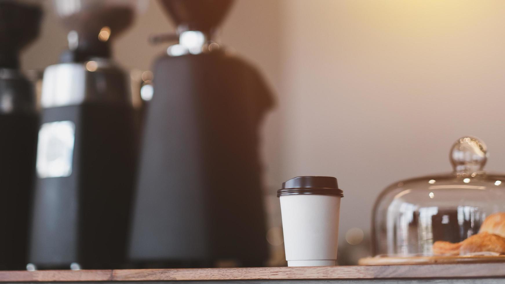 heißen Kaffee zum Mitnehmen auf dem Tisch im Café. Pappbecher heißen Kaffee. wegbringen. foto