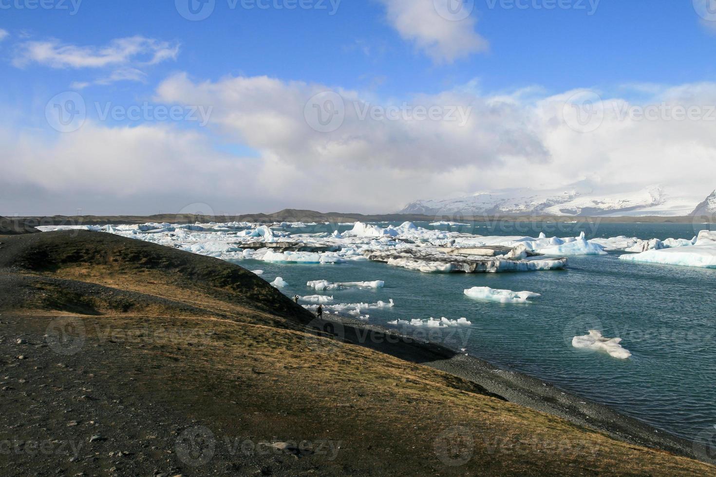 Heller klarer blauer Eisberg, der im blauen kalten Wasser des Jokulsarlon-Sees in Island schwimmt 65 foto