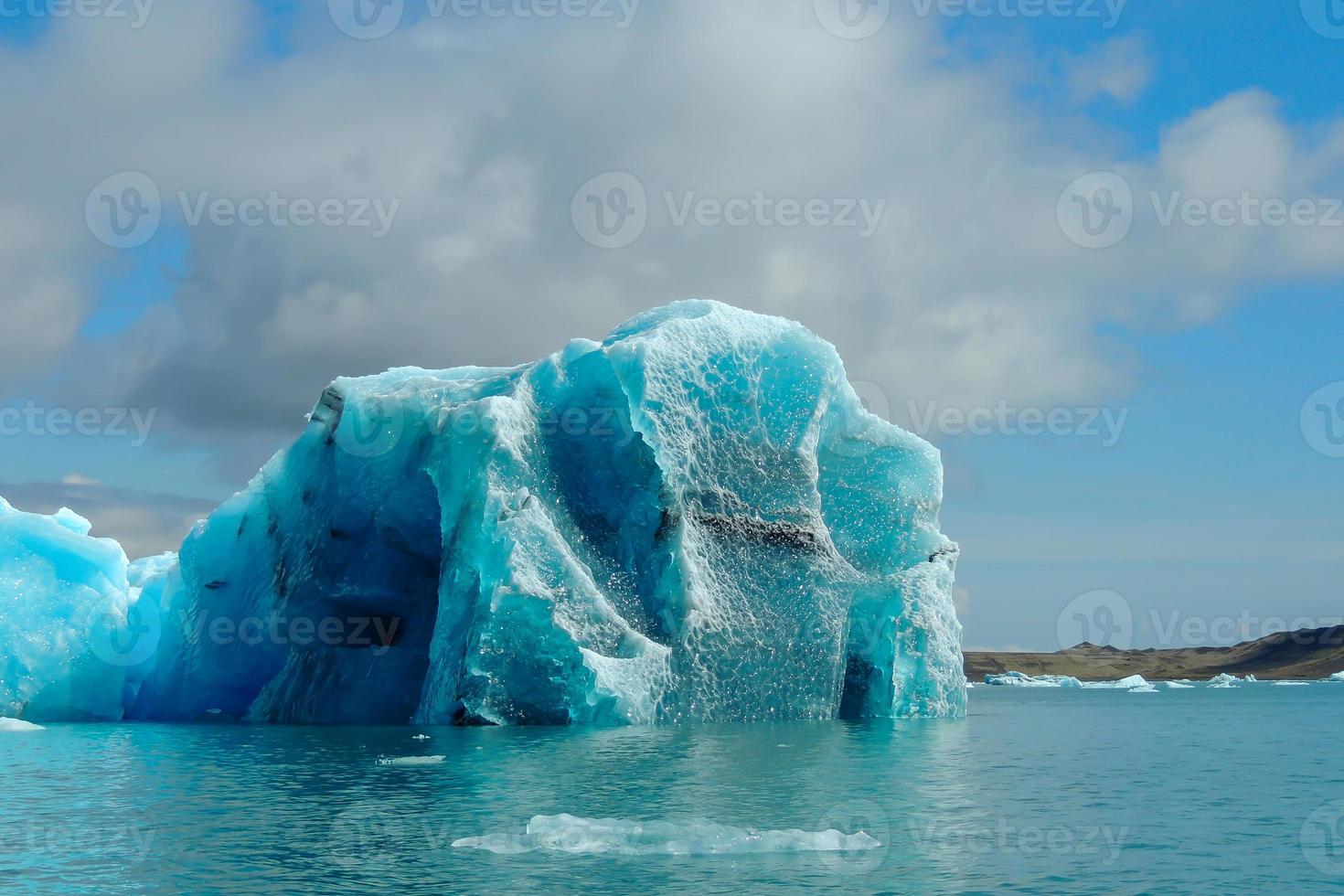 Heller klarer blauer Eisberg, der im blauen kalten Wasser des Jokulsarlon-Sees in Island schwimmt 45 foto