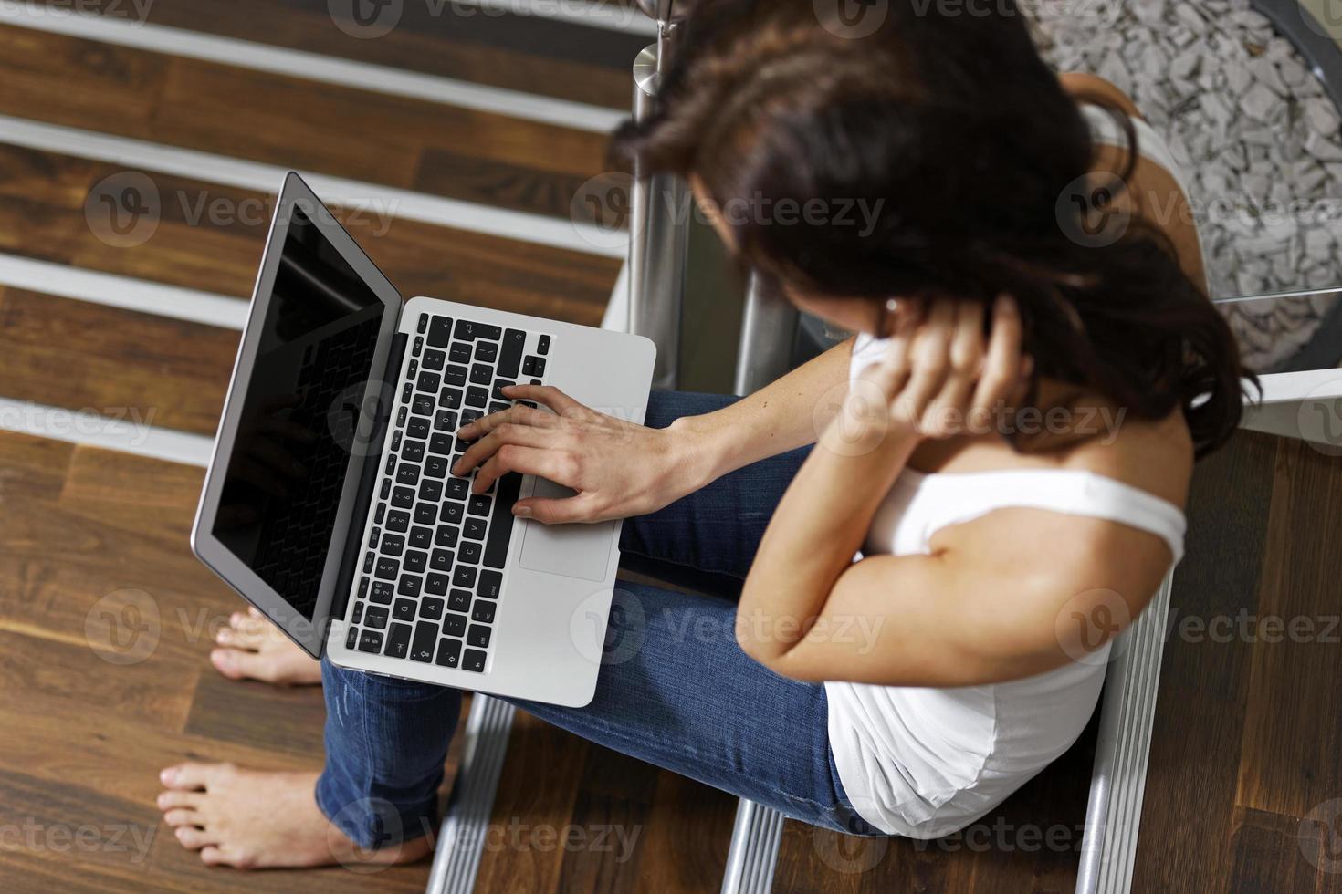Frau mit Laptop auf der Treppe foto