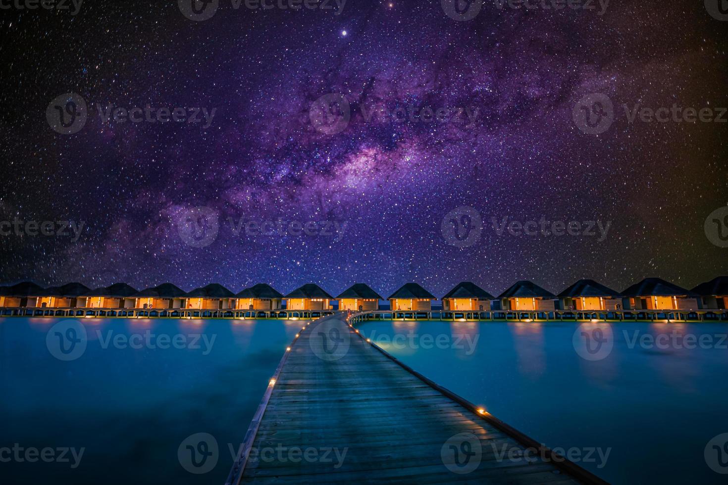 Luxus-Wasservillen-Resort und Holzsteg. schöner himmel und wolken und strandhintergrund für sommerferien und reisen. sonnenuntergangslandschaft am malediven-inselstrand, wasservillen-resort foto