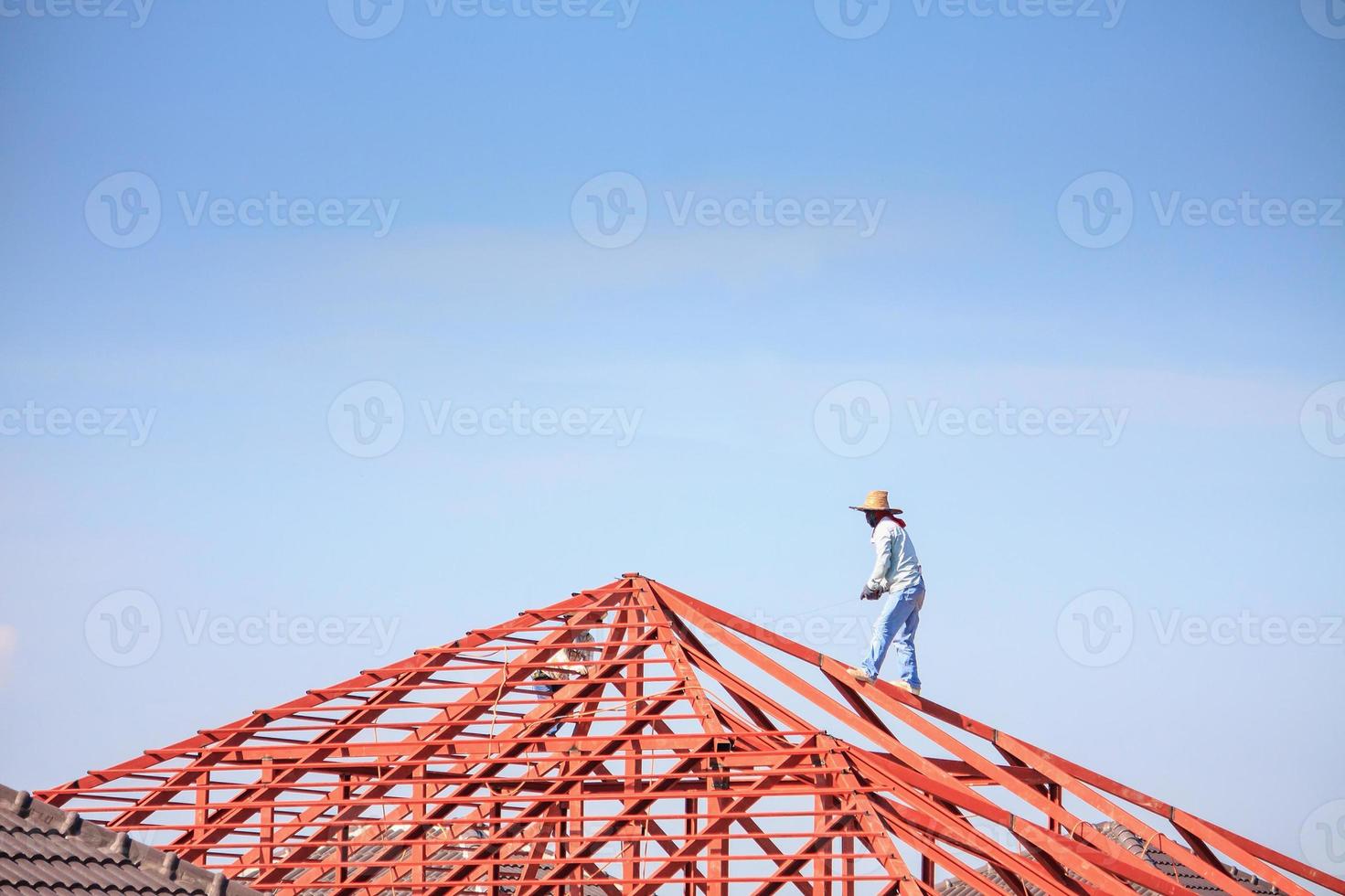 schweißer, die stahlrahmenkonstruktion des hausdaches auf der baustelle installieren foto