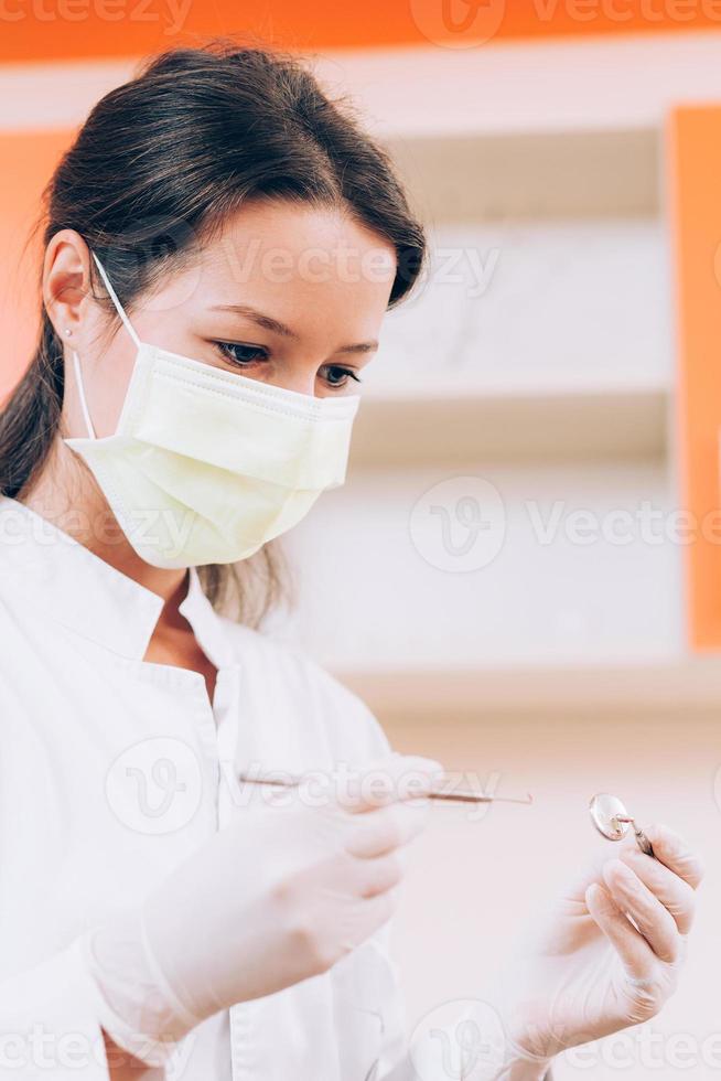 Zahnarzt hält Spiegel und Sonde foto