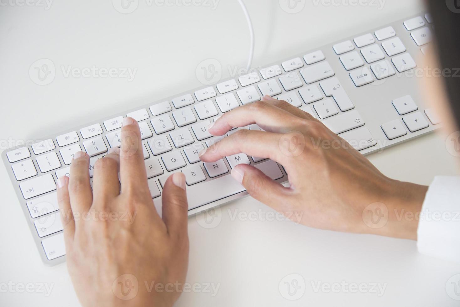 Hände einer Frau, die auf der Tastatur tippt foto