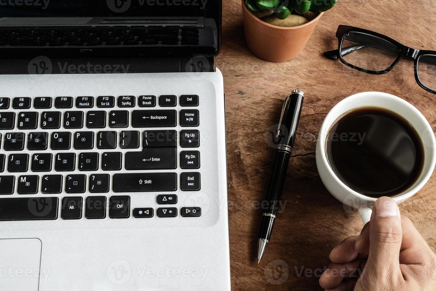Laptop und Tasse Kaffee auf altem Holztisch foto