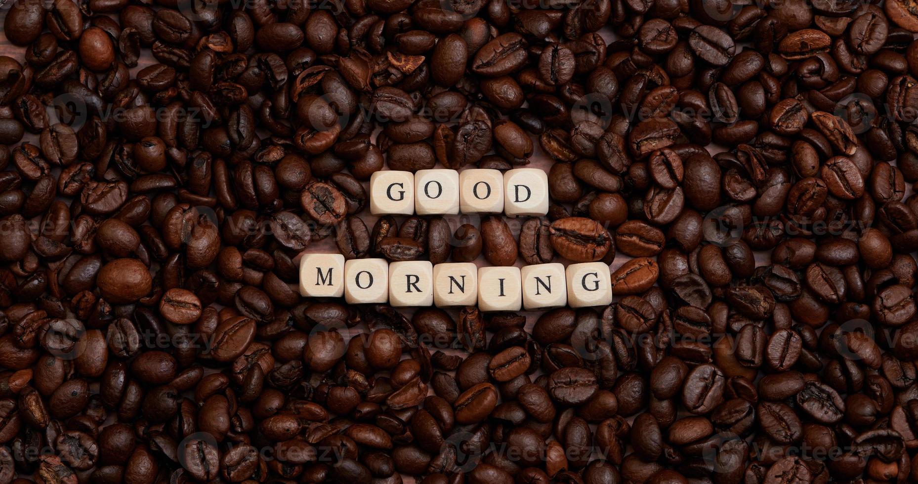 Text Guten Morgen inmitten vieler gerösteter Kaffeebohnen foto