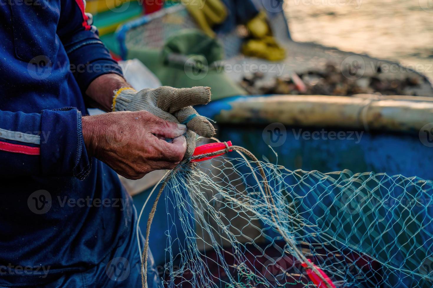 Fischer wirft sein Netz bei Sonnenaufgang oder Sonnenuntergang aus. Traditionelle Fischer bereiten das Fischernetz vor foto