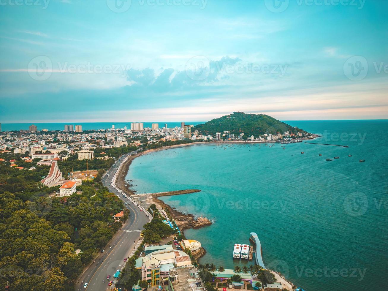 Luftaufnahme der Stadt Vung Tau mit wunderschönem Sonnenuntergang und so vielen Booten. Panoramablick auf die Küste von Vung Tau von oben, mit Wellen, Küste, Straßen, Kokospalmen und dem Berg Tao Phung in Vietnam. foto