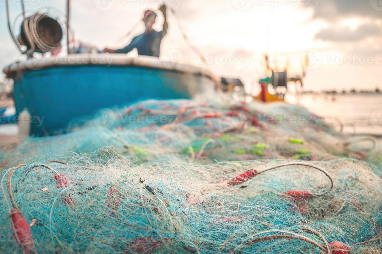 Seenetze - Angelausrüstung oder Tackle als Texturhintergrund mit natürlichem Sonnenlicht und Schatten. Blauer strukturierter Hintergrund von Fischernetzen aus nächster Nähe, Meeresdesign für das Handwerk der Fischer. foto
