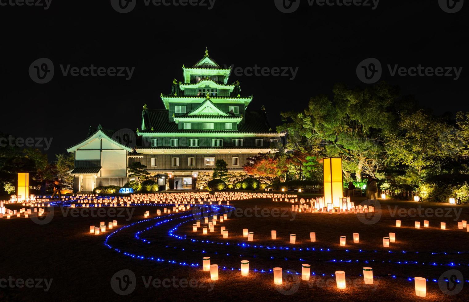 okayama schloss mit laternen, die nachts in okayama, japan aufleuchten foto