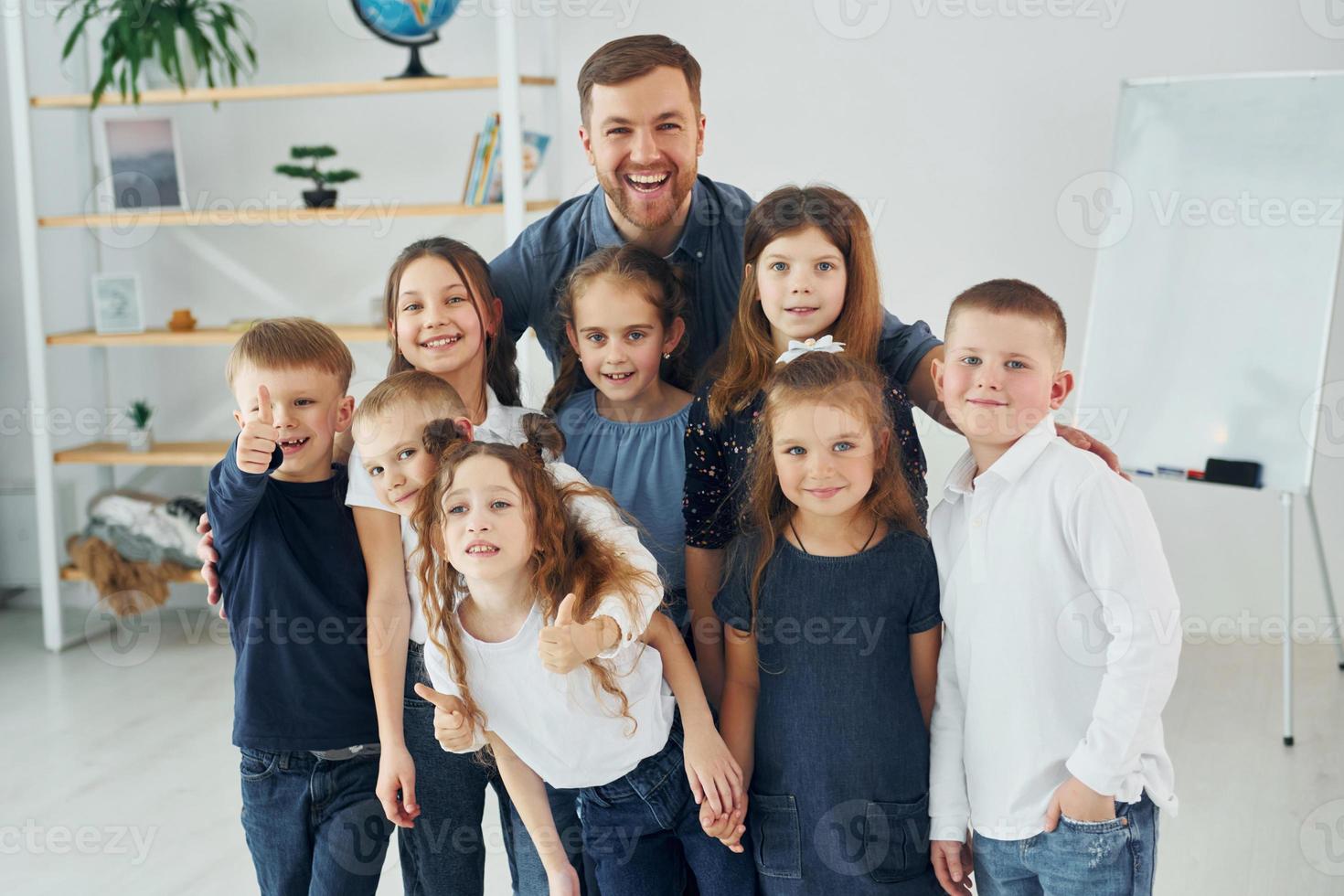 zusammen stehen. gruppe von kinderschülern im unterricht in der schule mit lehrer foto