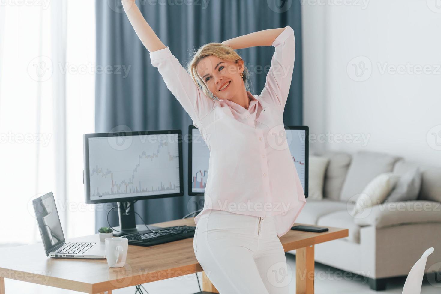 glücklich aussehen. weibliche börsenmaklerin in formeller kleidung arbeitet im büro foto