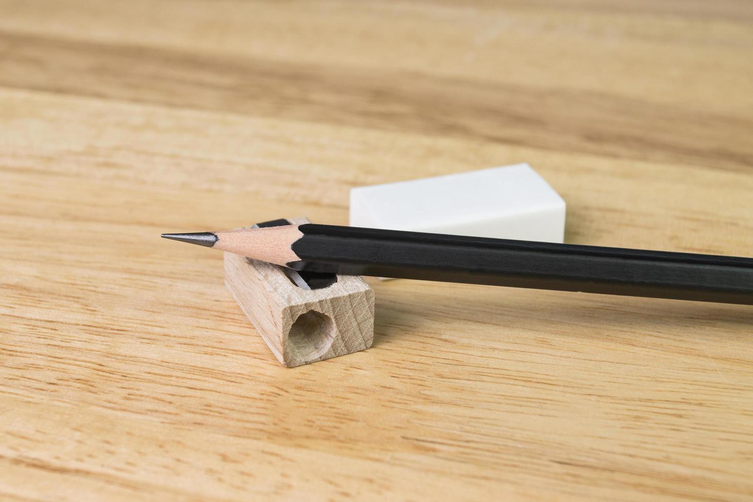 Bleistift und Anspitzer auf Holztisch foto