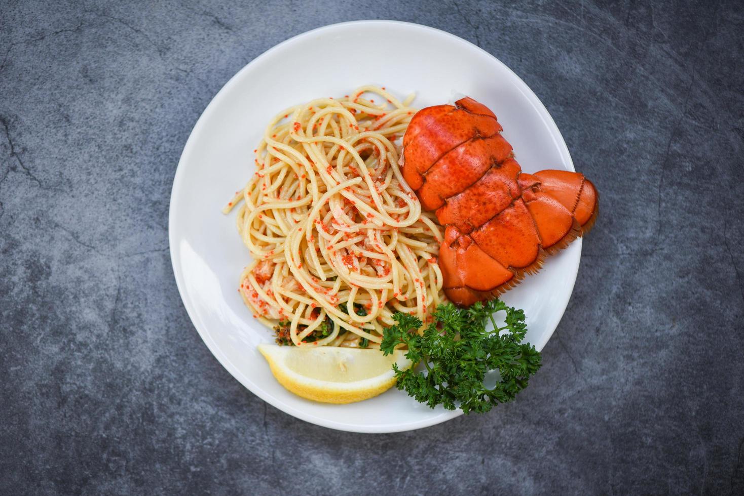 Spaghetti Meeresfrüchte Hummer Essen auf einem weißen Teller - Spaghetti Garnelen Ei Abendessen mit Kräuter Gewürzen Zitrone serviert Tisch im Restaurant Gourmet-Essen gesund gekocht Hummerschwanz gekocht foto