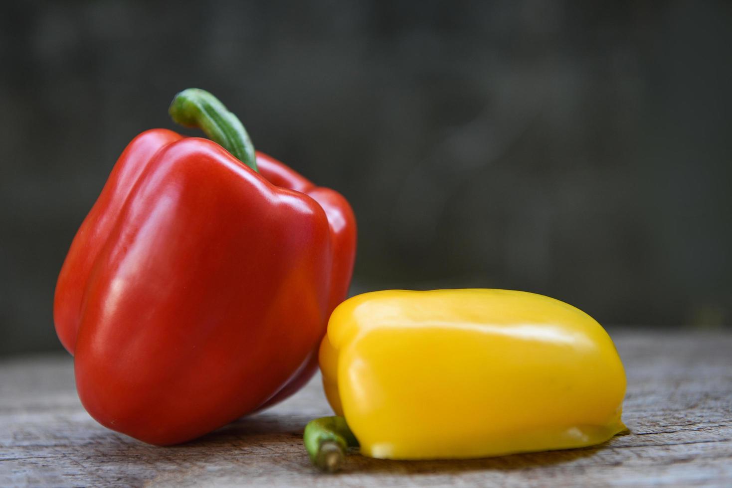 gelber und roter Paprika - frische Paprikaglocke auf Holzhintergrund foto