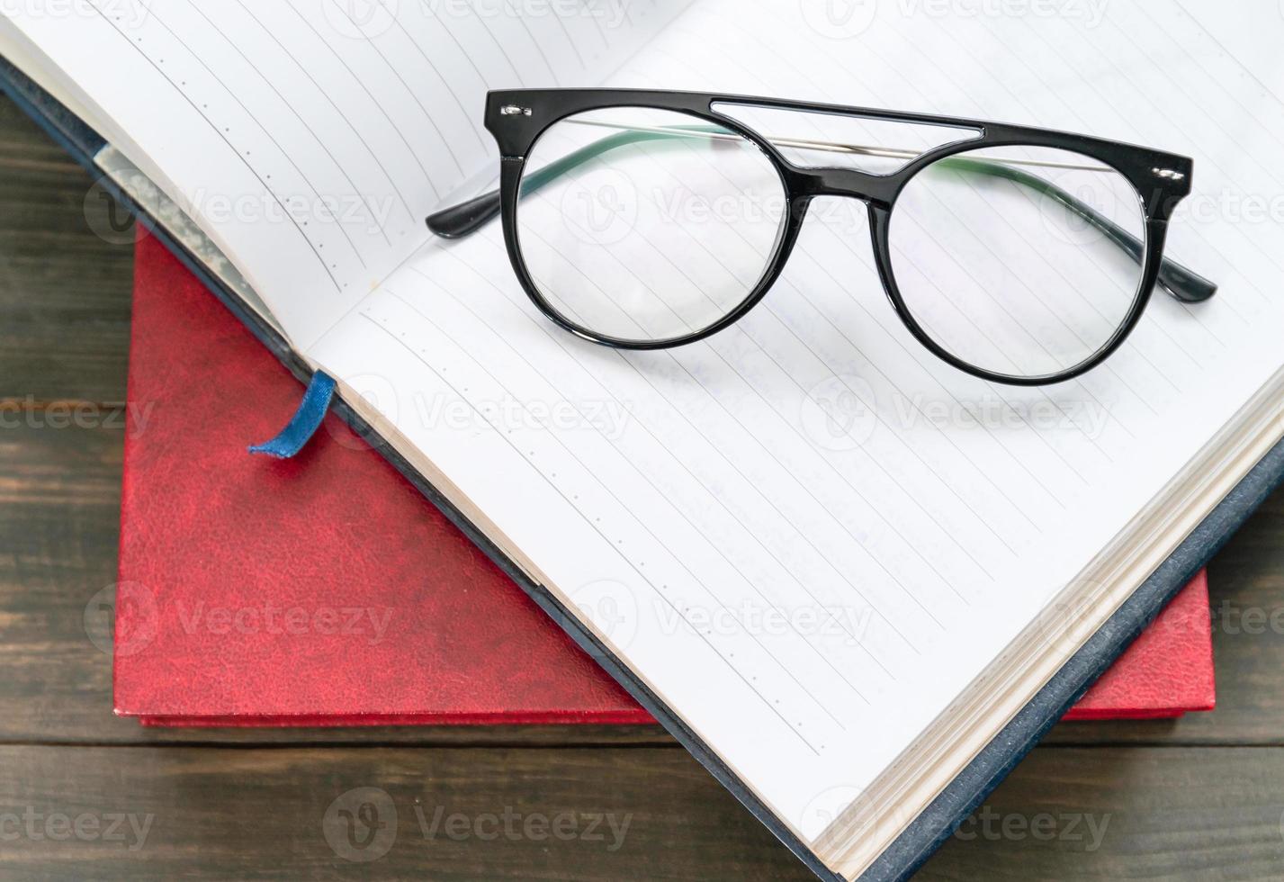 Lesebrille auf offenes Buch setzen foto