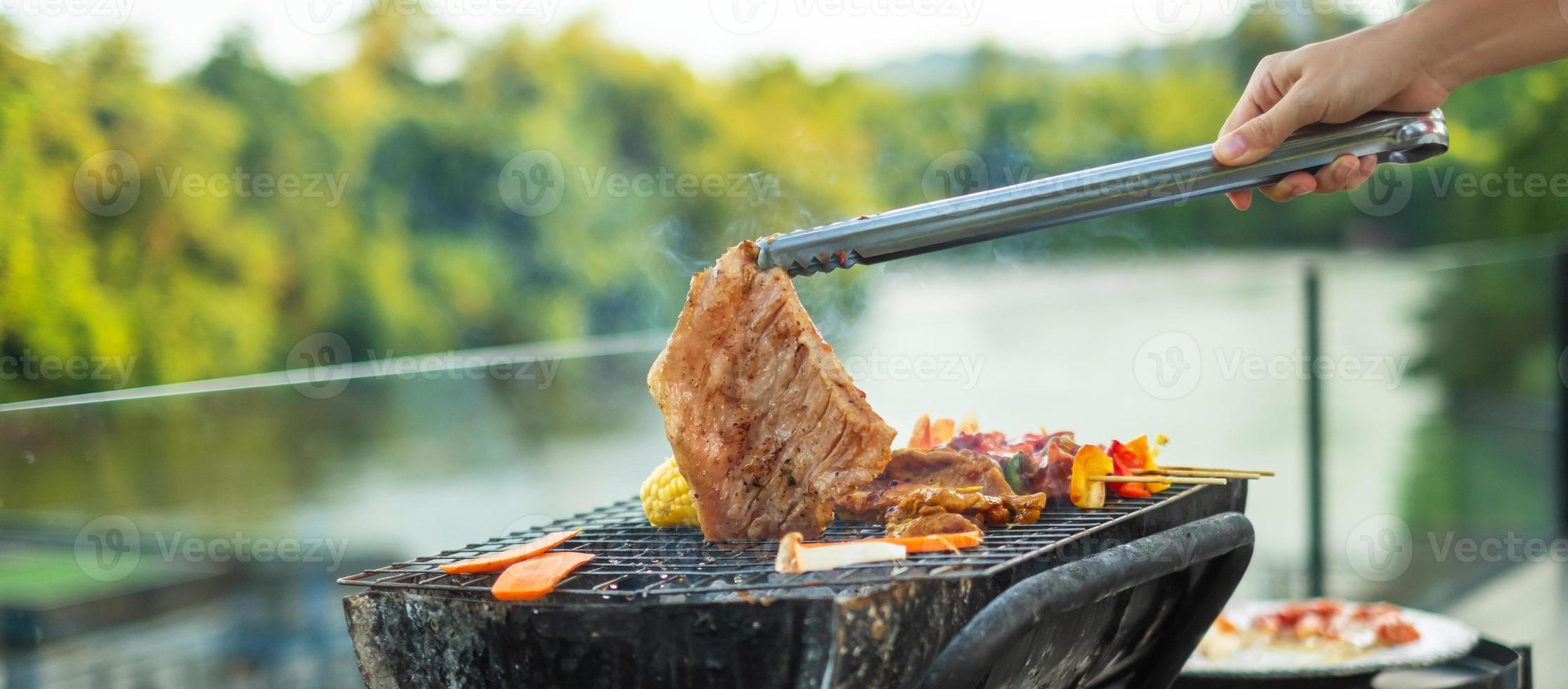 leckeres gegrilltes fleisch mit rauch, grill mit gemüse im freien. grill-, party-, lifestyle- und picknickkonzept foto