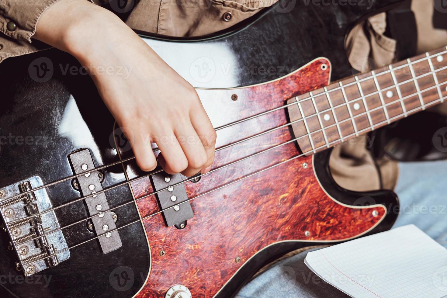 Nahaufnahme von weiblichen Händen, die E-Bass-Gitarre spielen. Schnittansicht. Rock-Konzert-Aufführung foto