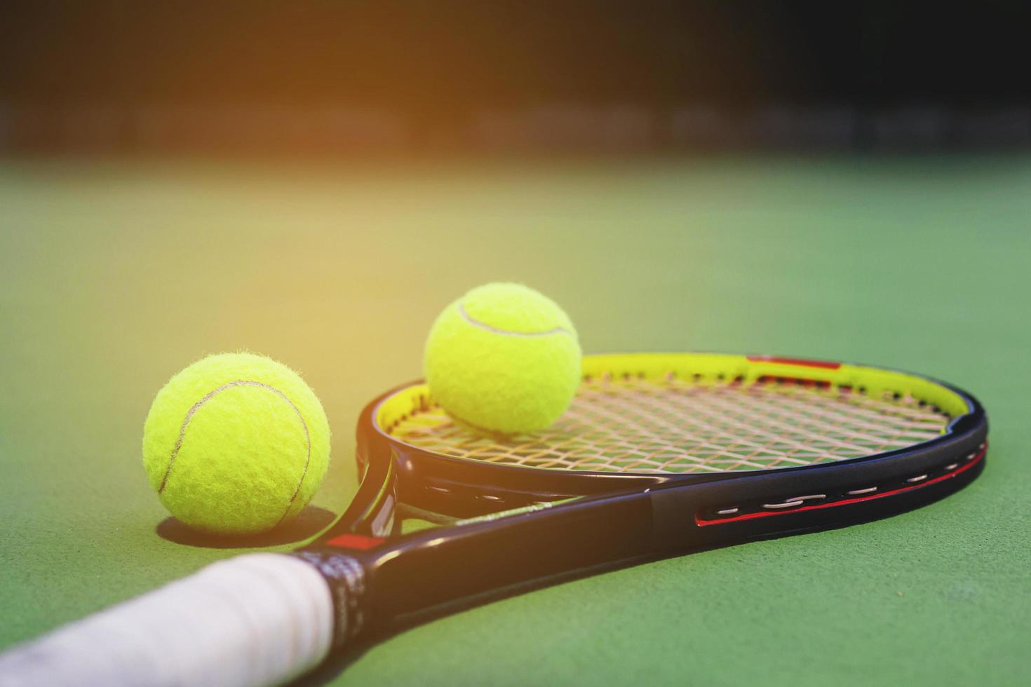 Tennisschläger mit Bällen auf dem Platz foto