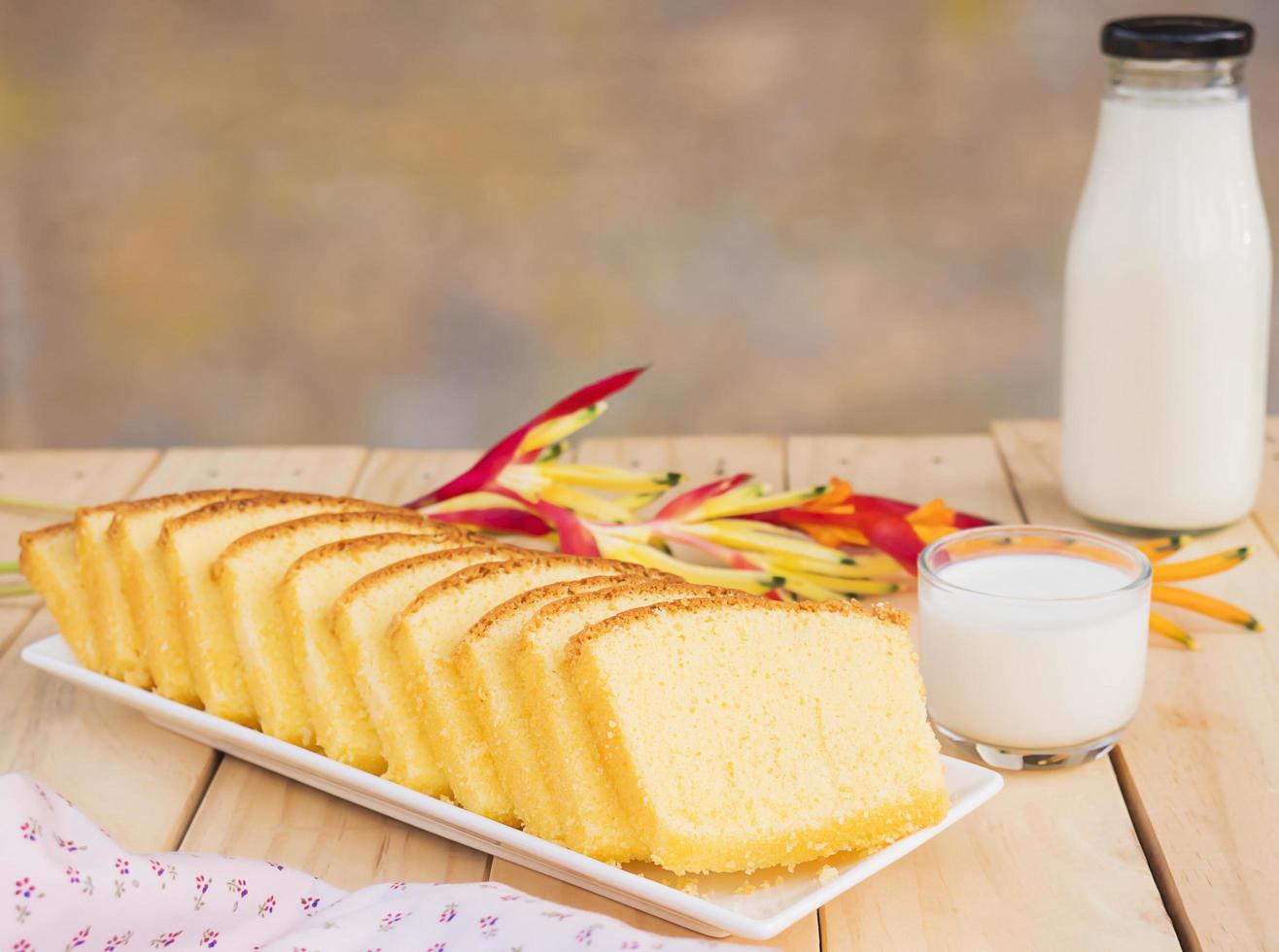 Butterkuchen und Flasche mit Glas Milch auf weißem Holztisch foto