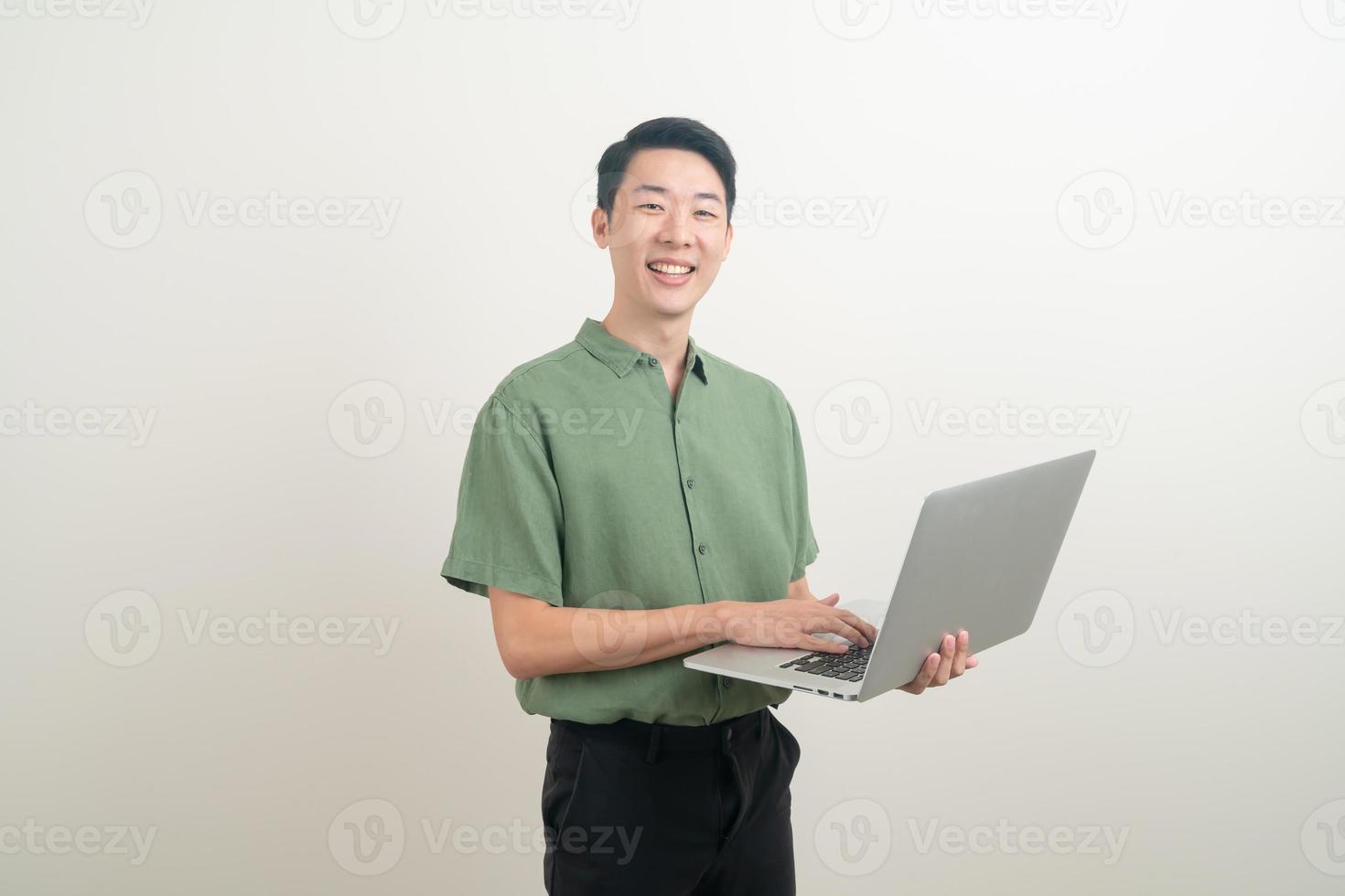 junger asiatischer Mann mit Laptop zur Hand foto