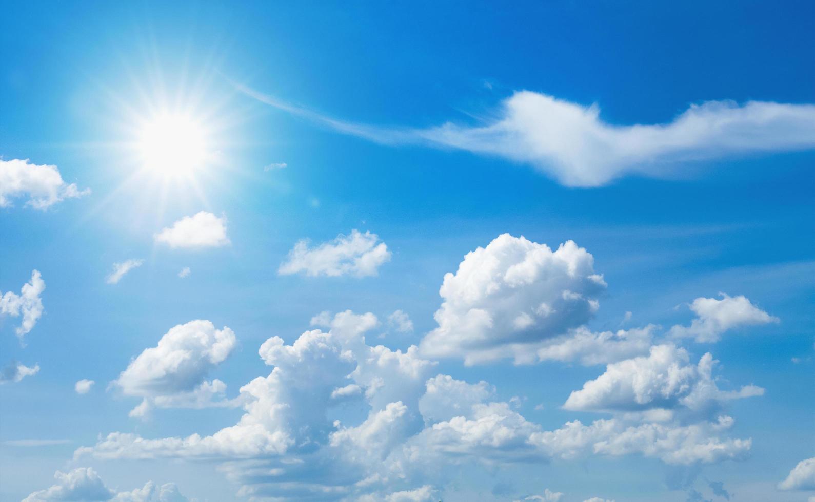 blauer Himmel mit weißen Wolken und Sonne foto