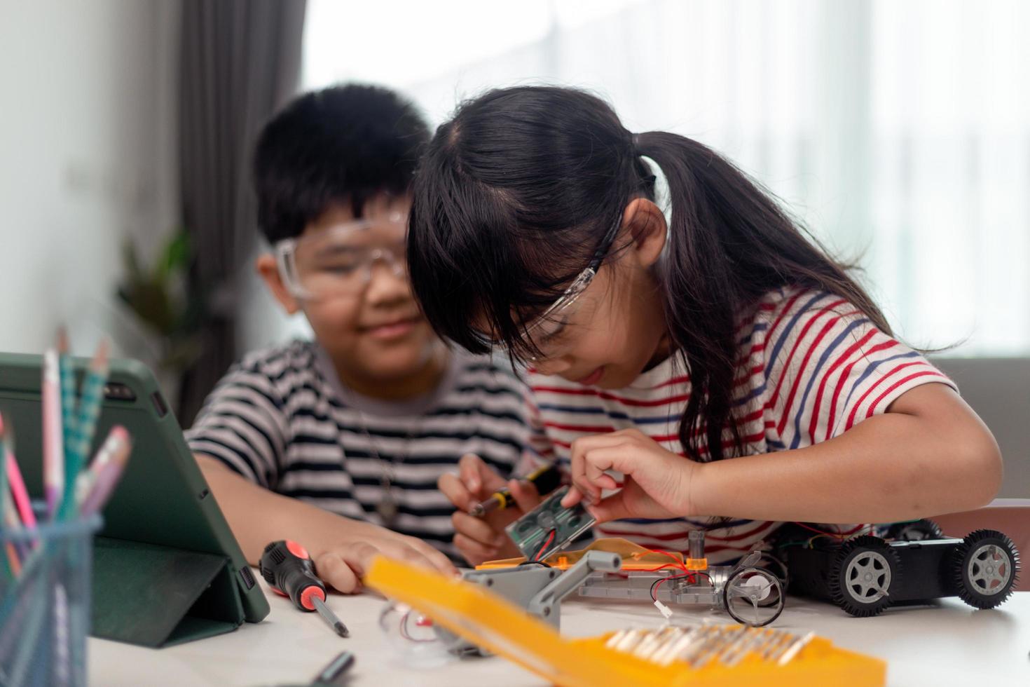 Zwei asiatische Kinder, die Spaß daran haben, gemeinsam Codierung zu lernen, zu Hause aus der Ferne zu lernen, Stammwissenschaft, Bildung zu Hause, Spaß an sozialer Distanzierung, Isolation, neues normales Konzept foto