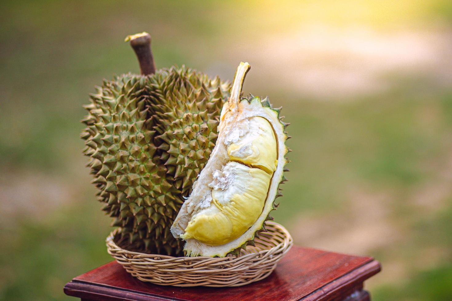 durian gereift und frisch, durianschale mit gelber farbe auf holztisch. foto