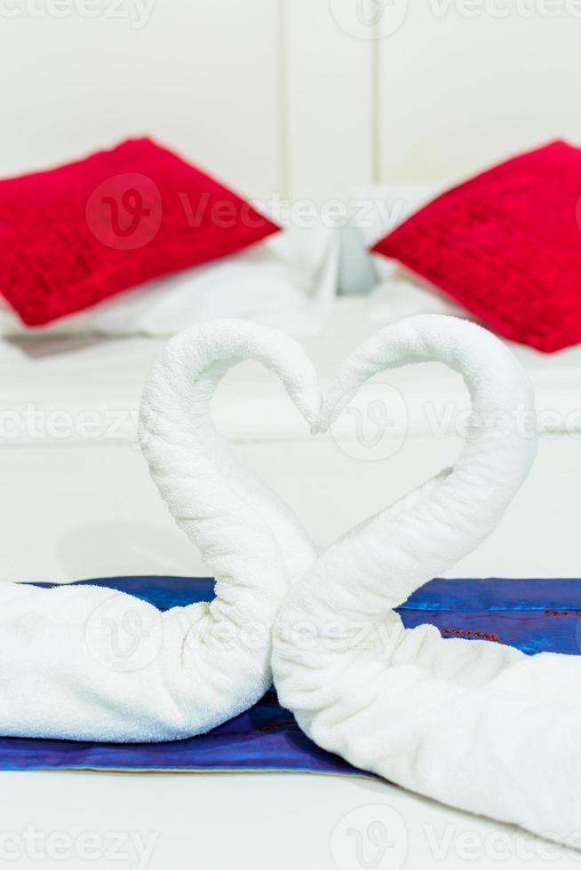 Handtuchschwäne geformt auf dem Bett foto