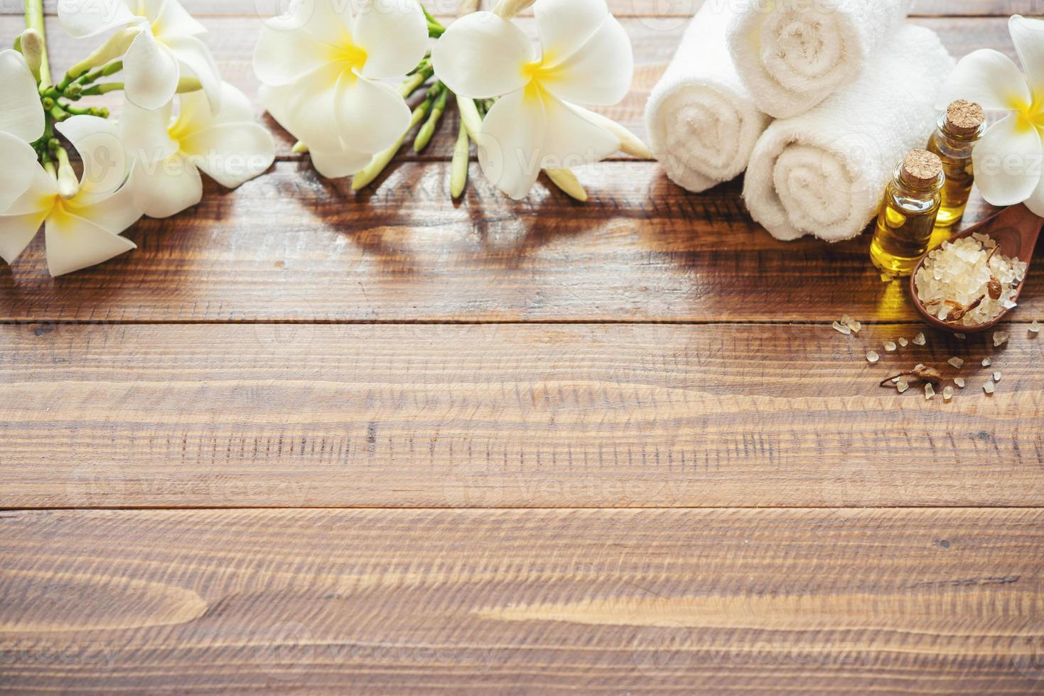 Meersalz, Handtücher, Aromaöl in Flaschen und Blumen auf Vintage-Holzhintergrund. selektiver Fokus. foto