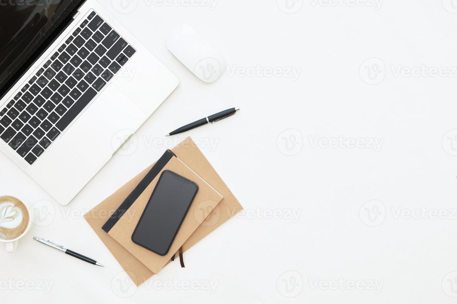 kreatives flaches lagdesign des arbeitsplatzschreibtisches mit laptop, laptop, leerem notizbuch, smartphone und briefpapier mit kopienraumhintergrund foto