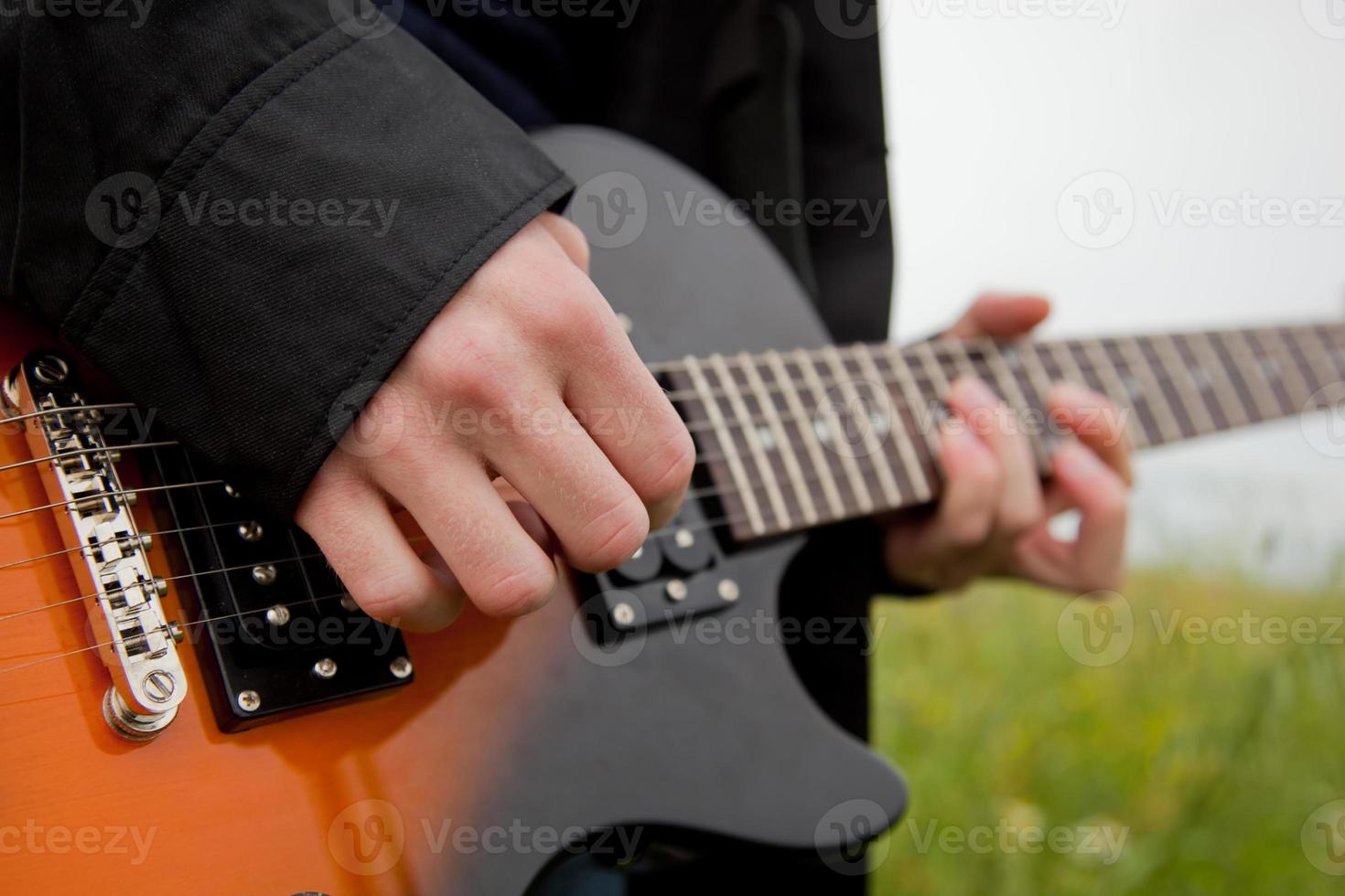 Nahaufnahme eines Mannes, der Gitarre spielt foto