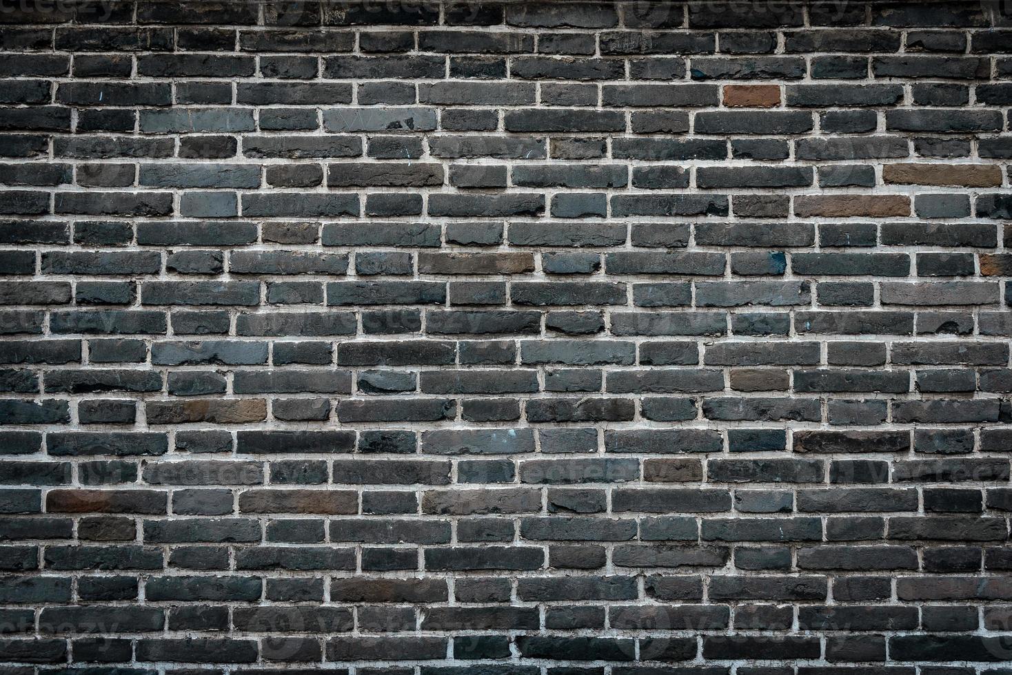 raue Backsteinmauer dunkler Stein Grunge Texturen Hintergrund. foto