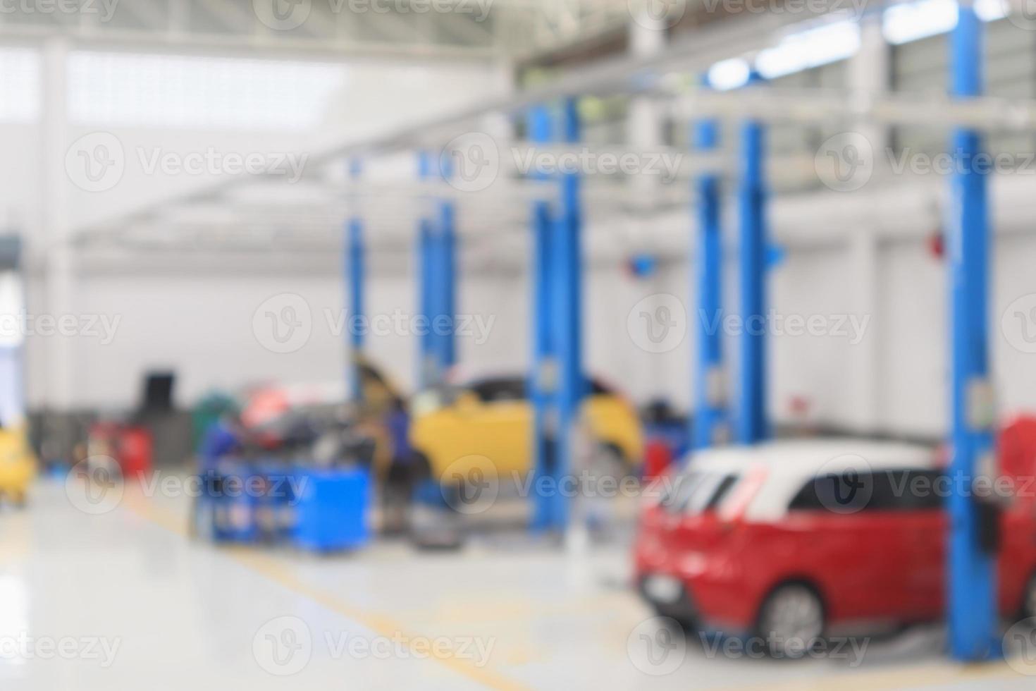 autoservicezentrum mit auto an der reparaturstation bokeh licht defokussierter unschärfehintergrund foto