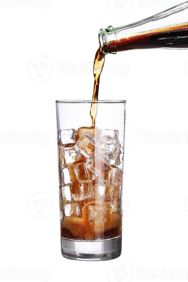 Flasche gießen Cola in Trinkglas mit Eiswürfeln isoliert foto