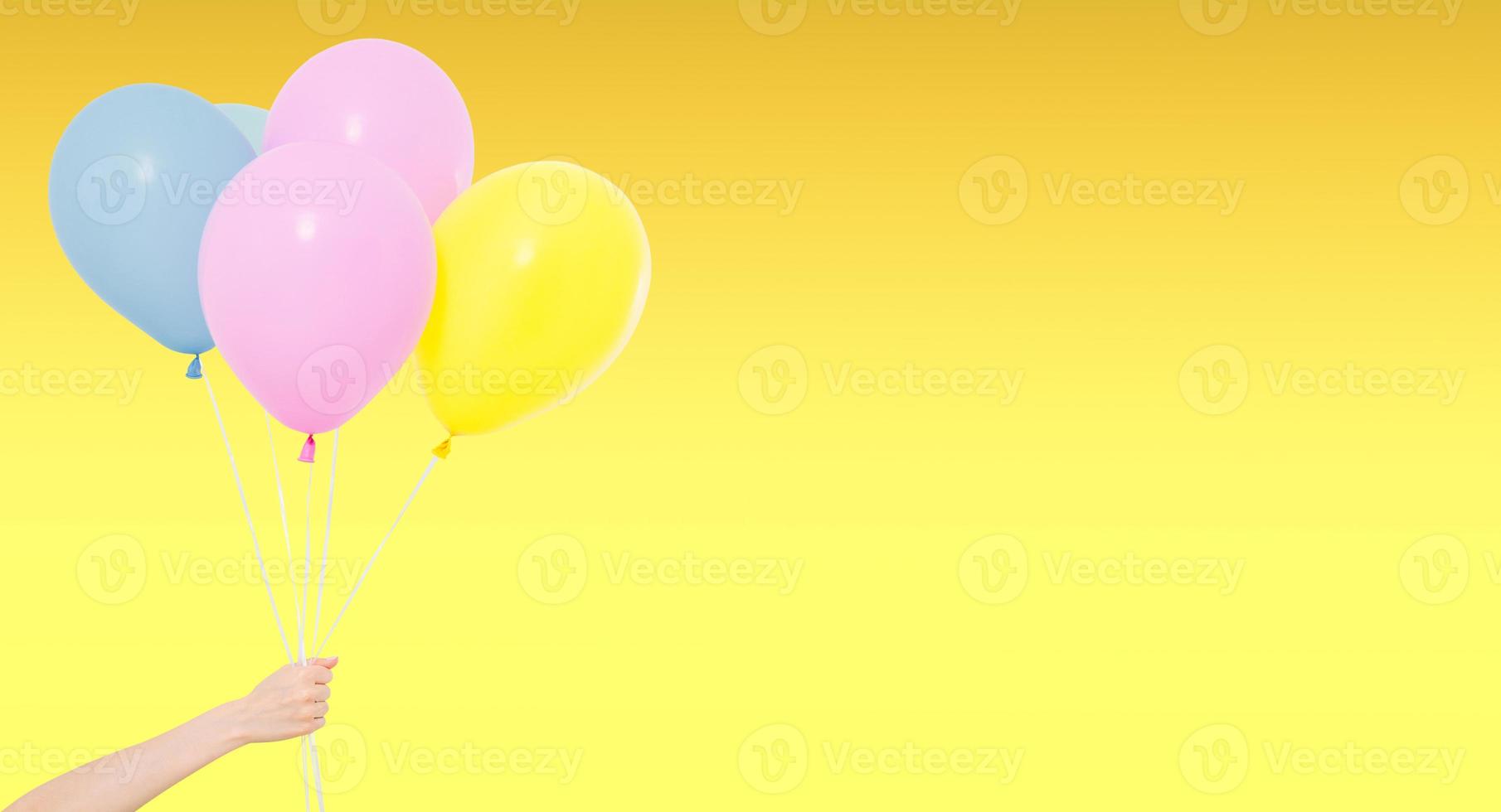 hand halten farbige luftballons isoliert auf gelbem hintergrund, urlaub und spaß foto