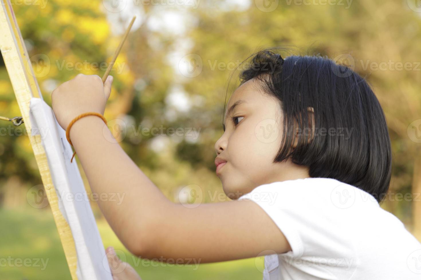 Asiatisches kleines Mädchen, das im Park malt foto