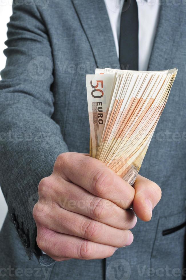 Mann im Anzug mit einem Bündel Euro-Scheine foto