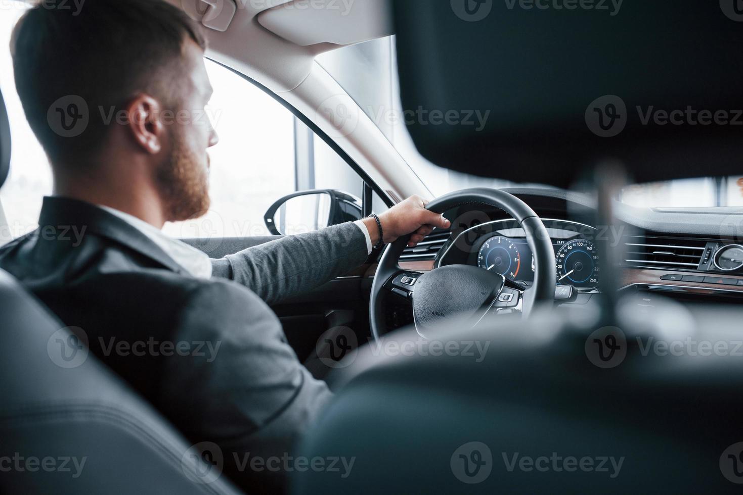 eine Person. moderner geschäftsmann, der sein neues auto im autosalon probiert foto